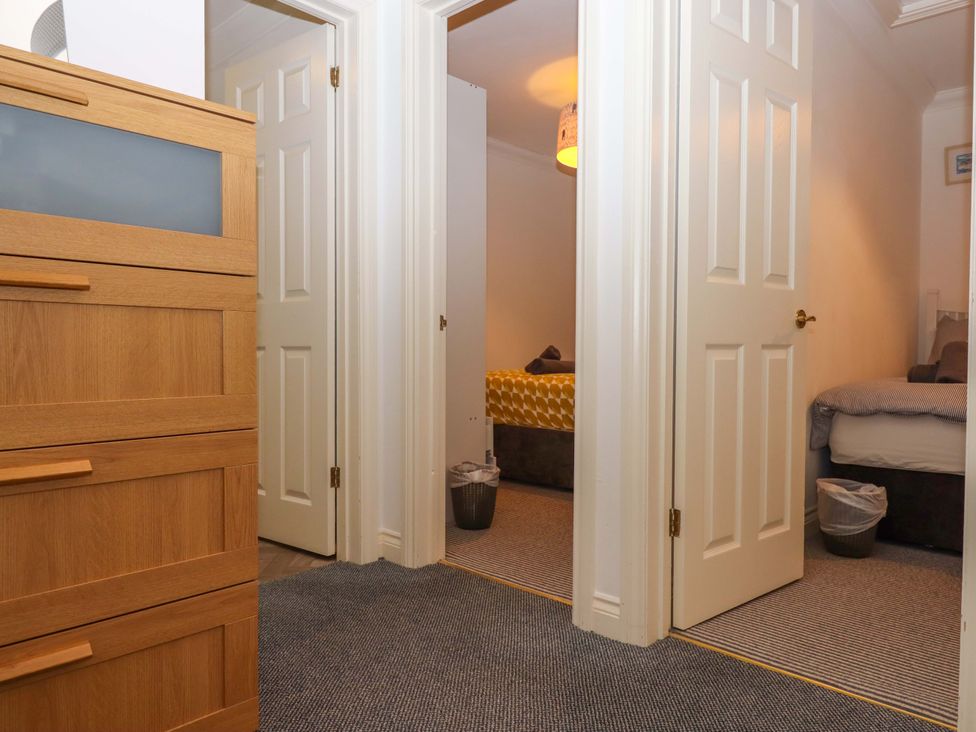A bedroom with a dresser and two doors at Cottage 1 Newcourt in Torquay