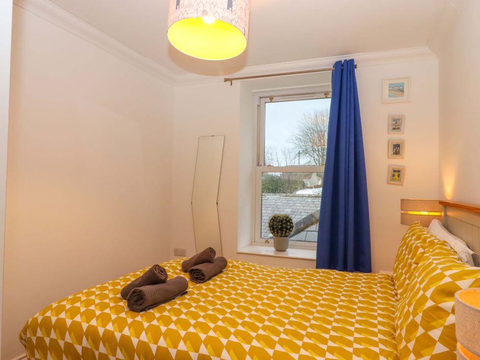 A bedroom with a bed and a window at Cottage 1 Newcourt in Torquay