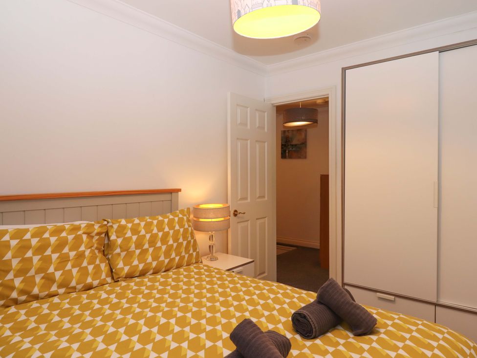 A bedroom with a bed and wardrobe at Cottage 1 Newcourt in Torquay