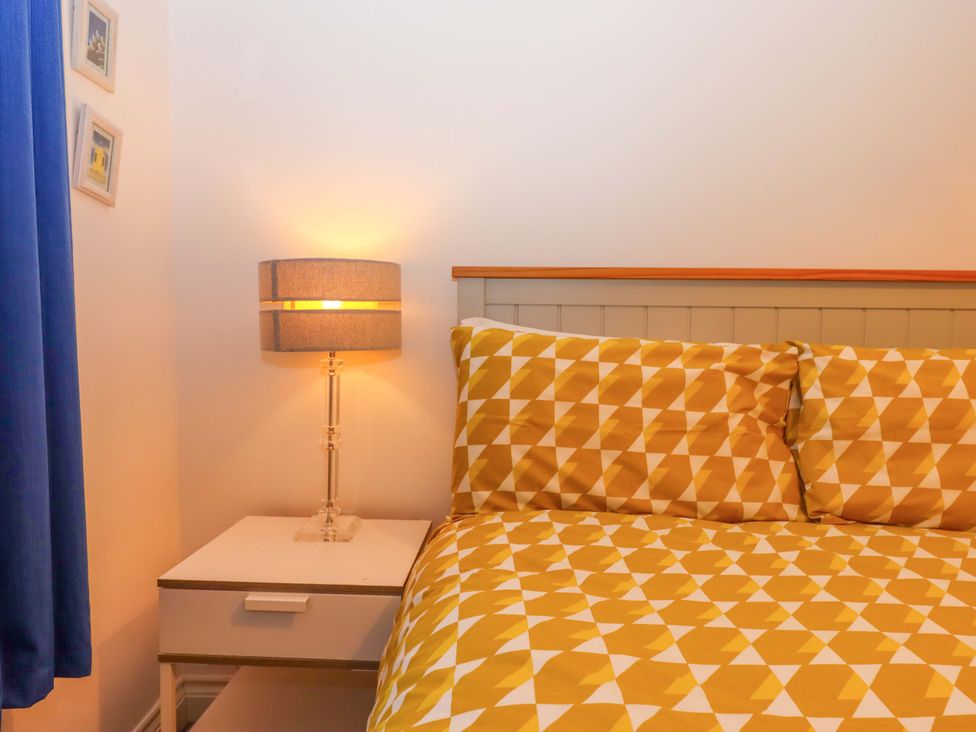 A bedroom with a bed and nightstand at Cottage 1 Newcourt in Torquay