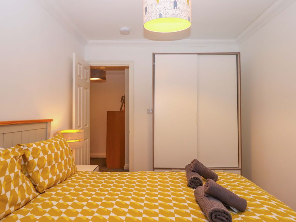 A bedroom with a bed and wardrobe at Cottage 1 Newcourt in Torquay