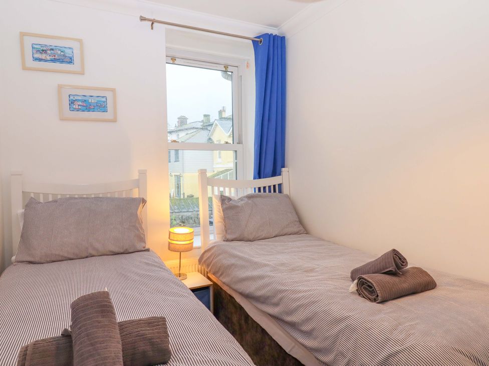 A bedroom with two single beds and a lamp at Cottage 1 Newcourt in Torquay