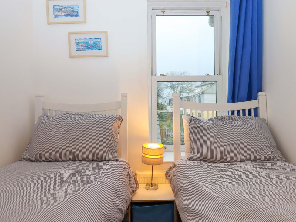 A bedroom with two beds and a lamp at Cottage 1 Newcourt in Torquay