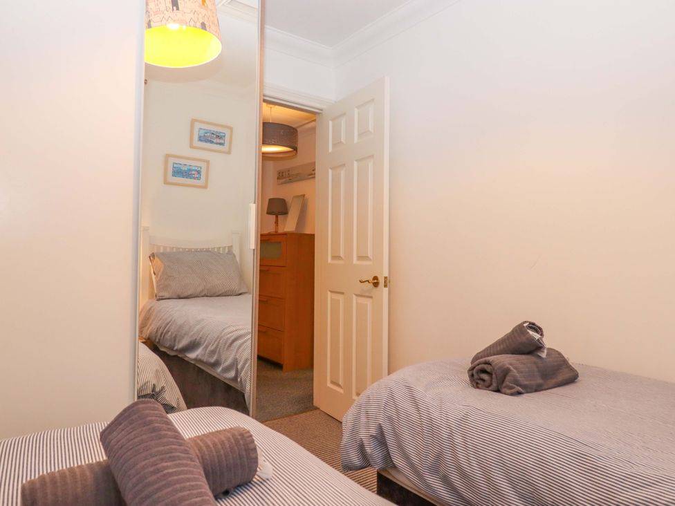 A bedroom with two beds and a dresser at Cottage 1 Newcourt in Torquay