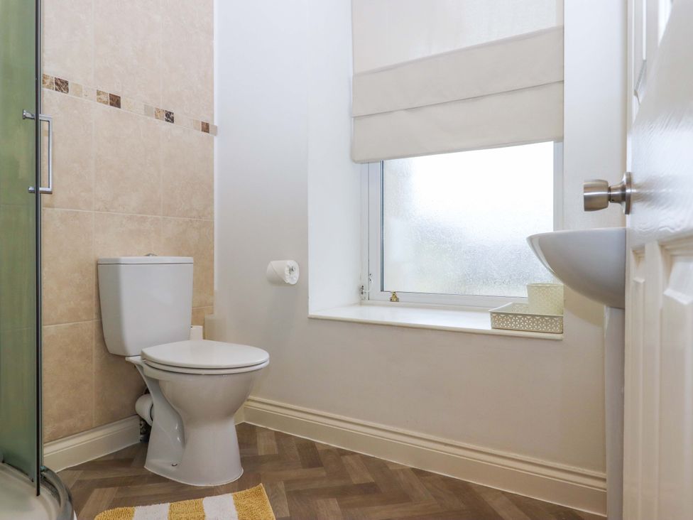 A bathroom with toilet, sink, and shower at Cottage 1 Newcourt in Torquay
