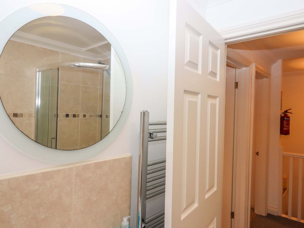 A bathroom with a mirror and a shower at Cottage 1 Newcourt in Torquay