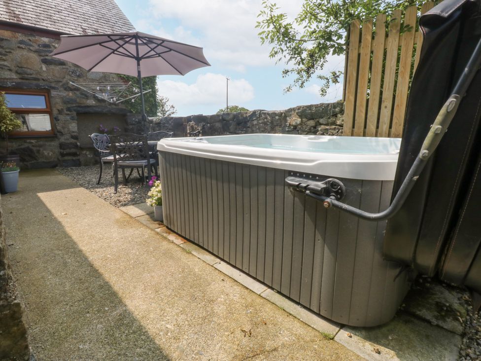 An outdoor space featuring a hot tub and seating area at Cegin Foch in Chwilog