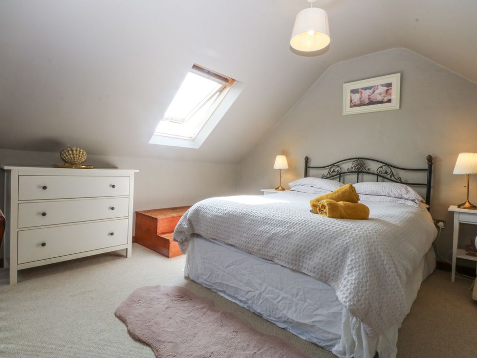 A bedroom with a bed and furniture at Cegin Foch in Chwilog