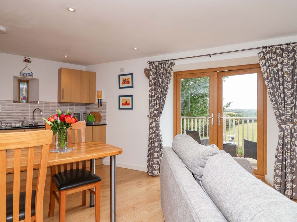 A living room with a dining area and kitchen at Cawsand Tideford