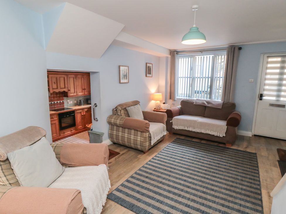 A living room with sofas and a kitchen area at Bramla in Staithes
