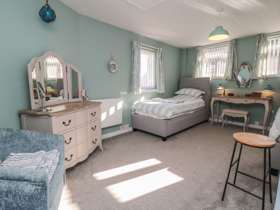 A bedroom with a bed and dressing table at Bramla in Staithes