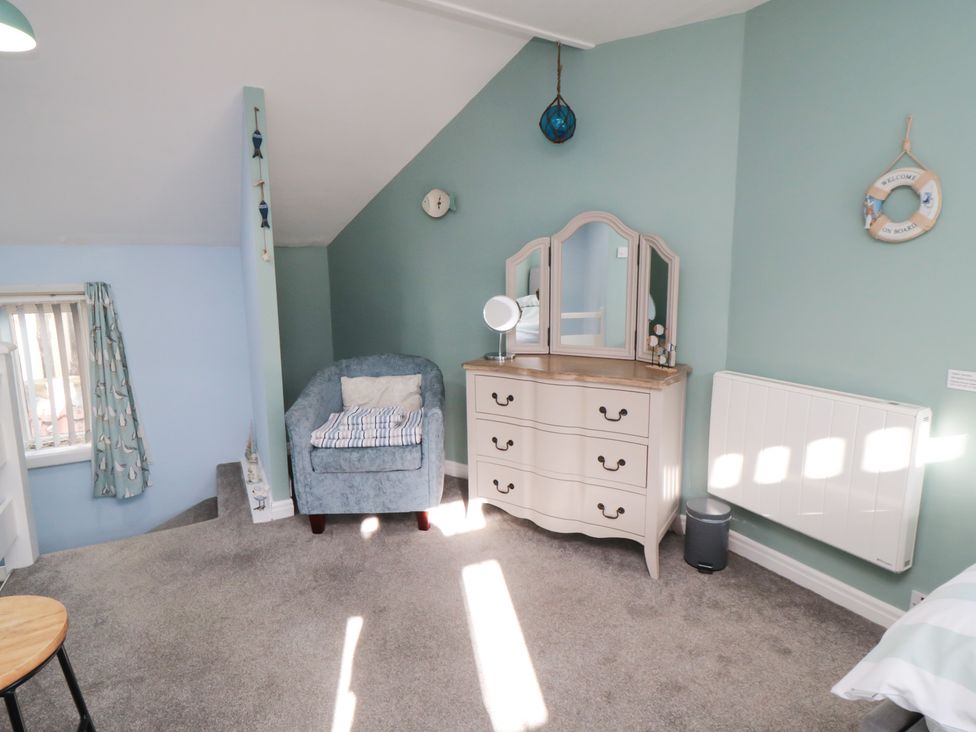 A bedroom with a chair and dressing table at Bramla in Staithes