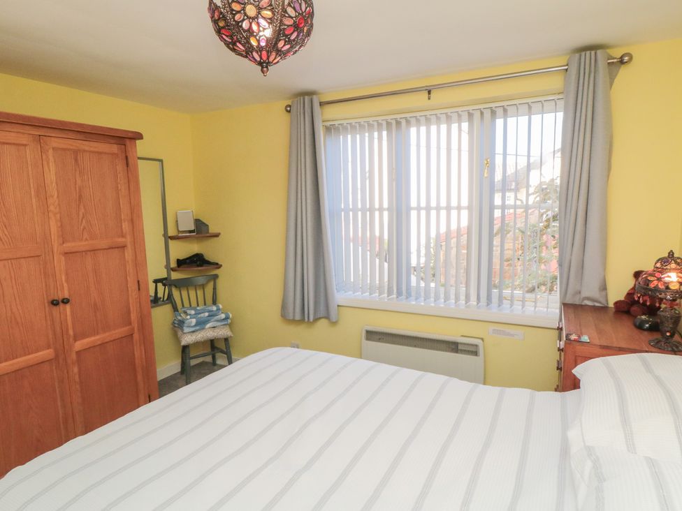 A bedroom with a bed and wardrobe at Bramla in Staithes