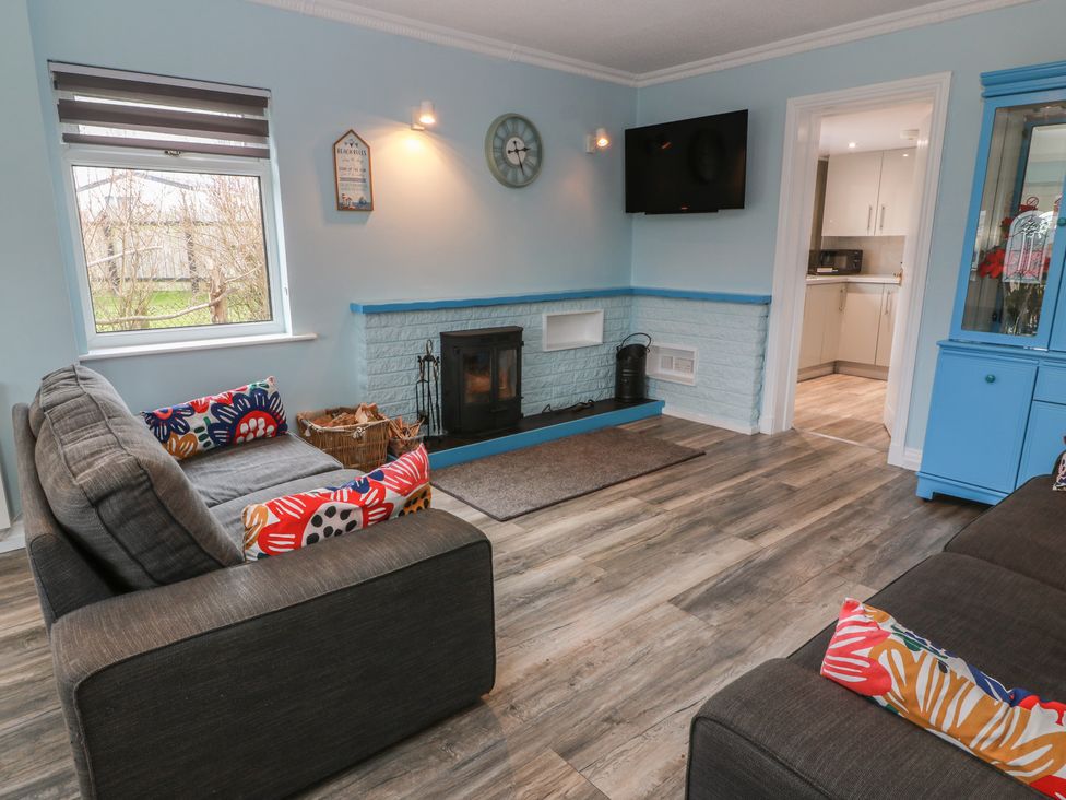 A living room with a fireplace and a television at Mardan in Southerness