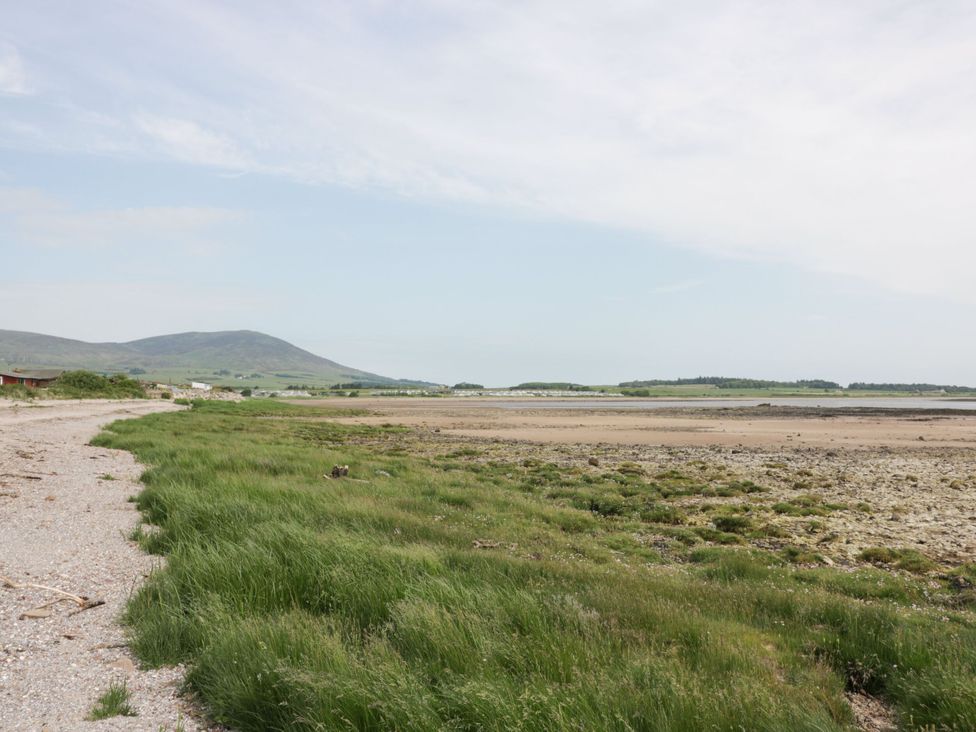A beach landscape with grass and a mountain at Mardan in Southerness