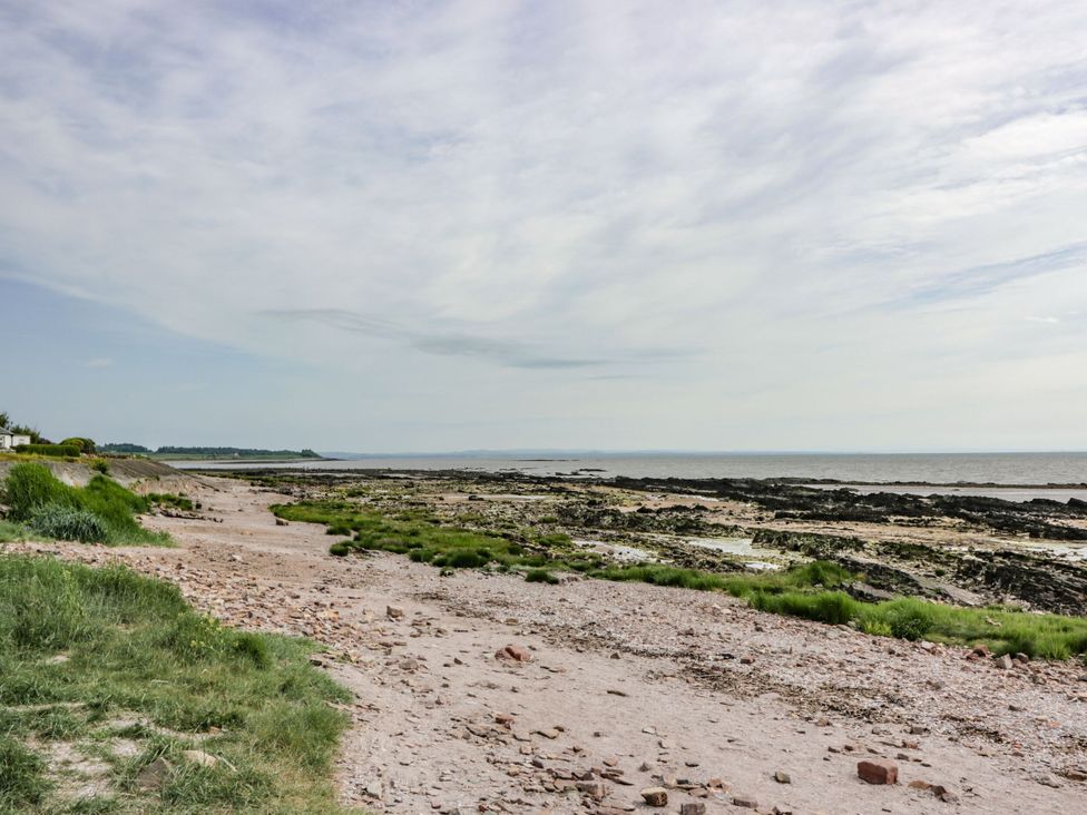 A beach with rocks and grass at Mardan Southerness