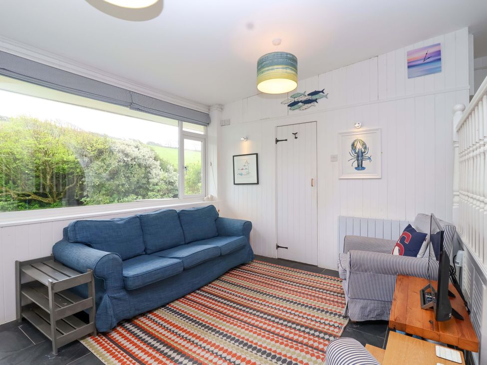 A living room with a sofa and television at 2 Brook Cottages in Hope Cove
