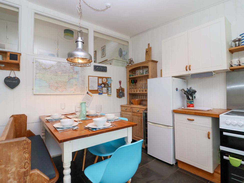 A kitchen with a dining table and chairs at 2 Brook Cottages Hope Cove