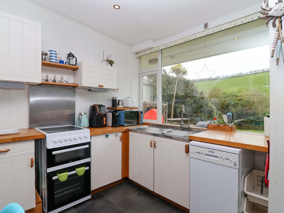A kitchen equipped with appliances at 2 Brook Cottages in Hope Cove