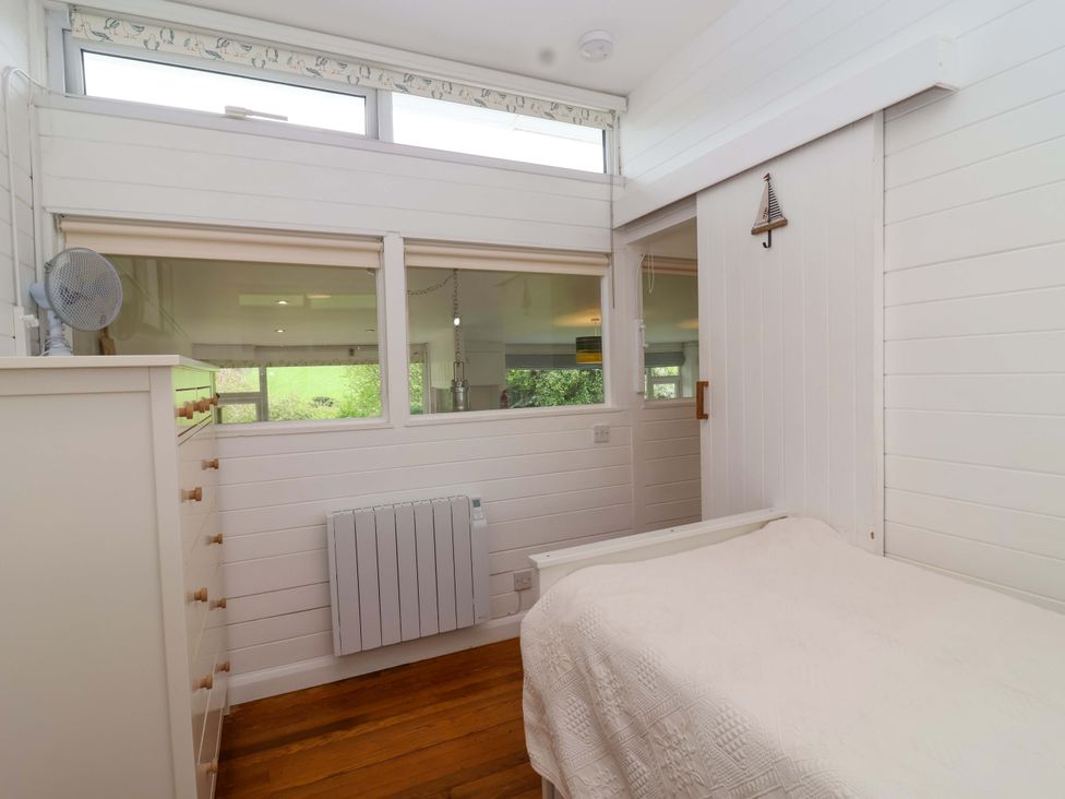 A bedroom with a bed and window at 2 Brook Cottages in Hope Cove