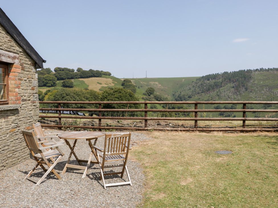 An outdoor area with a table and chairs at Penrhiwarwydd Barn in Pontywaun