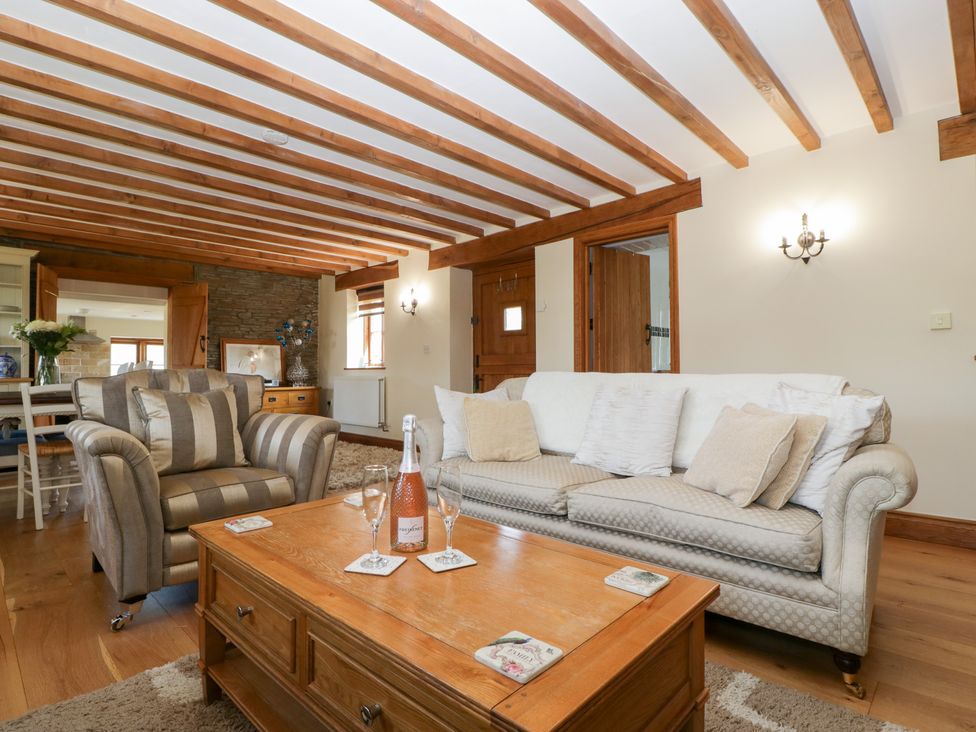 A living room with a sofa and armchair at Penrhiwarwydd Barn in Pontywaun