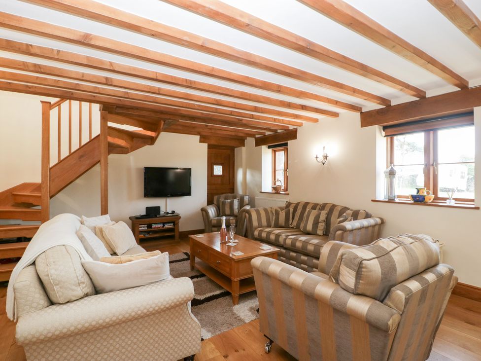 A living room with a sofa and television at Penrhiwarwydd Barn in Pontywaun