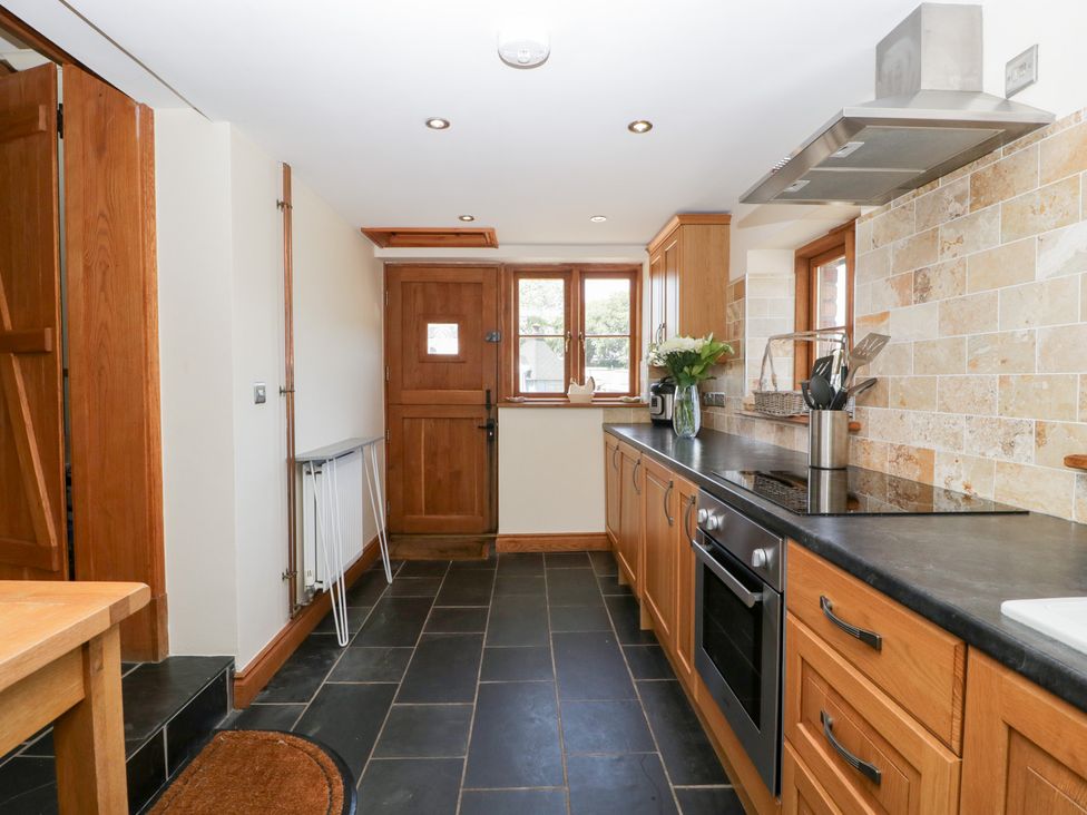 A kitchen with cabinets and appliances at Penrhiwarwydd Barn in Pontywaun