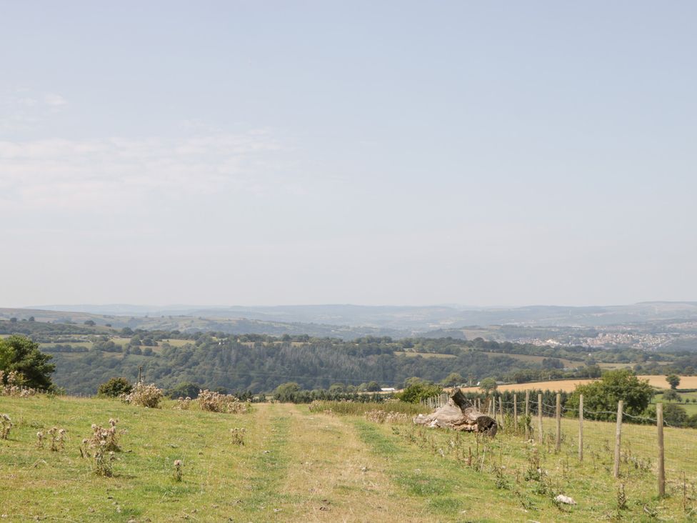 A field with a path and trees at Penrhiwarwydd Barn in Pontywaun