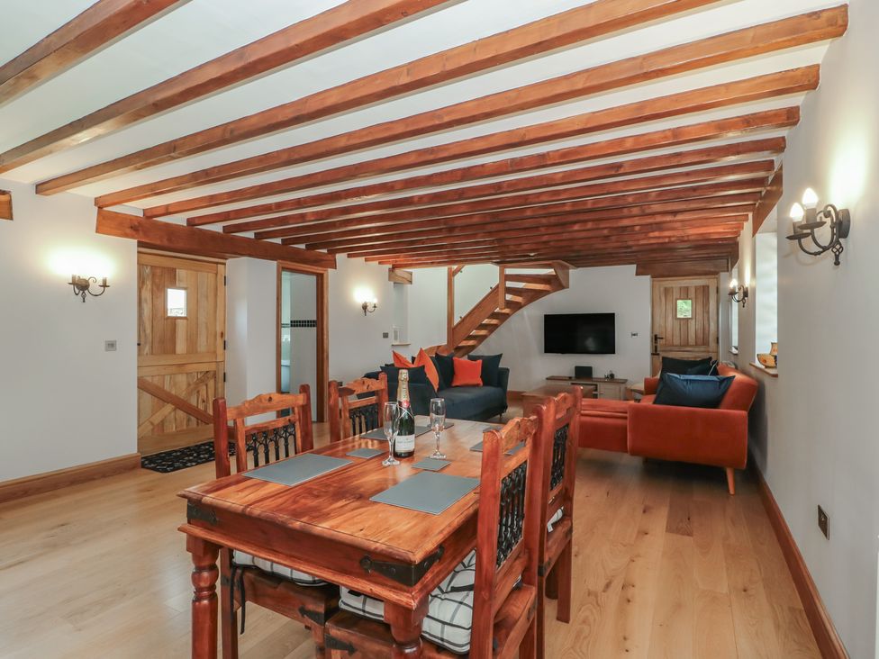 A living room with a dining table and sofa at Penrhiwarwydd Barn in Pontywaun