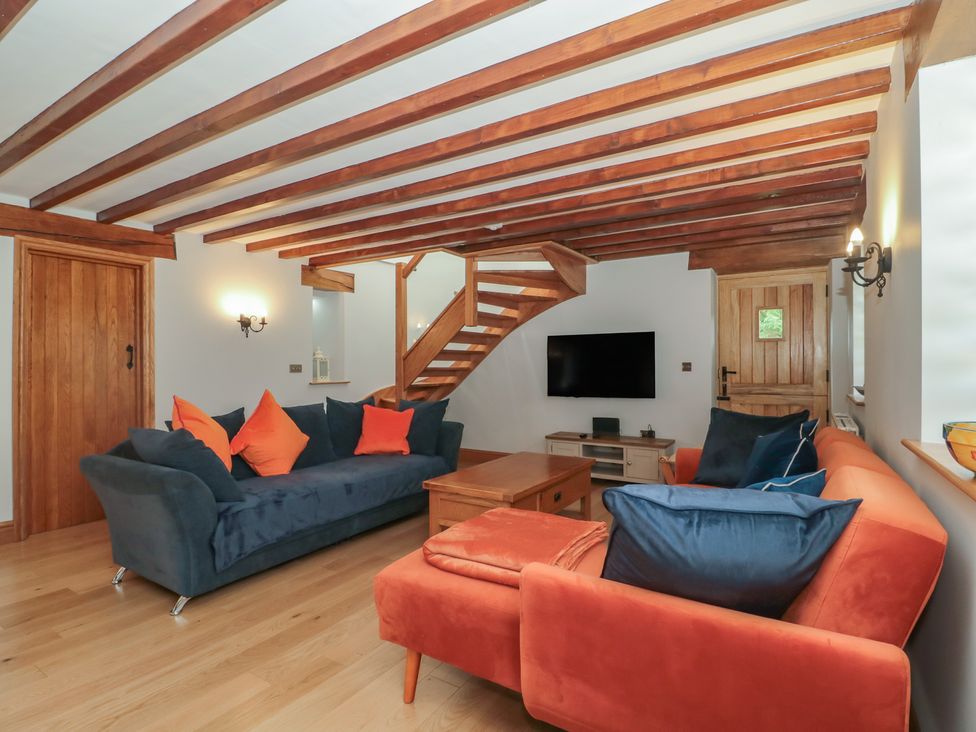 A living room with a sofa and a television at Penrhiwarwydd Barn in Pontywaun