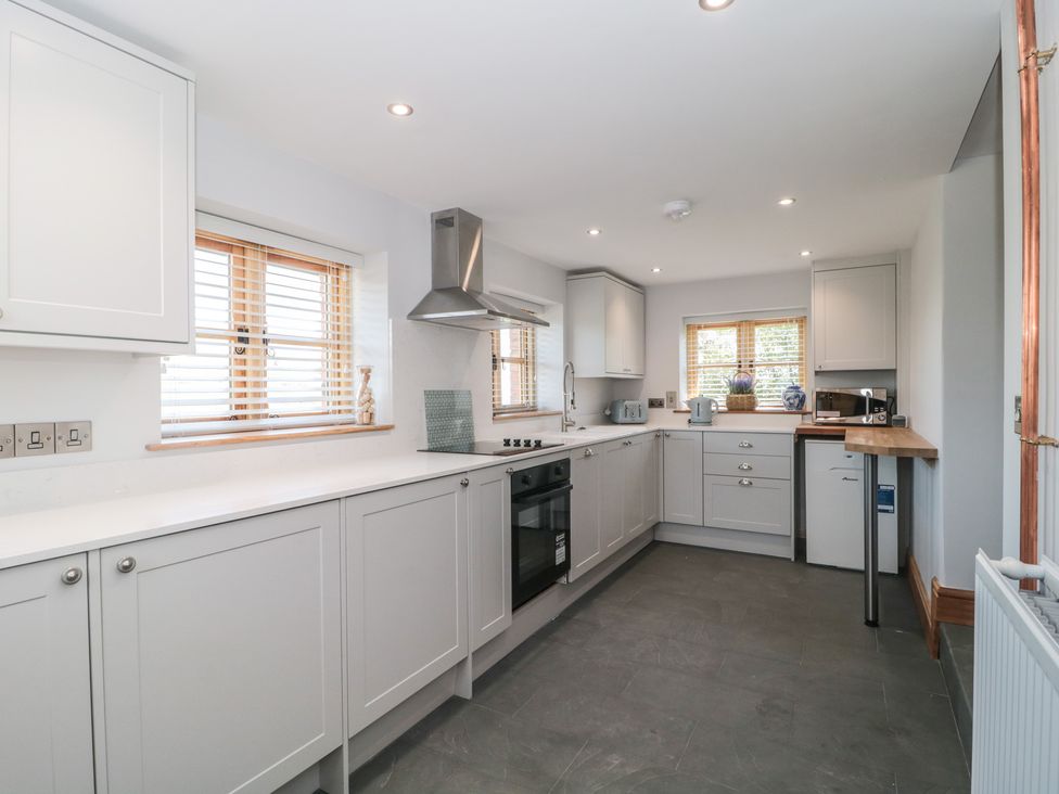 A kitchen with cabinets, countertop, and appliances at Penrhiwarwydd Barn in Pontywaun