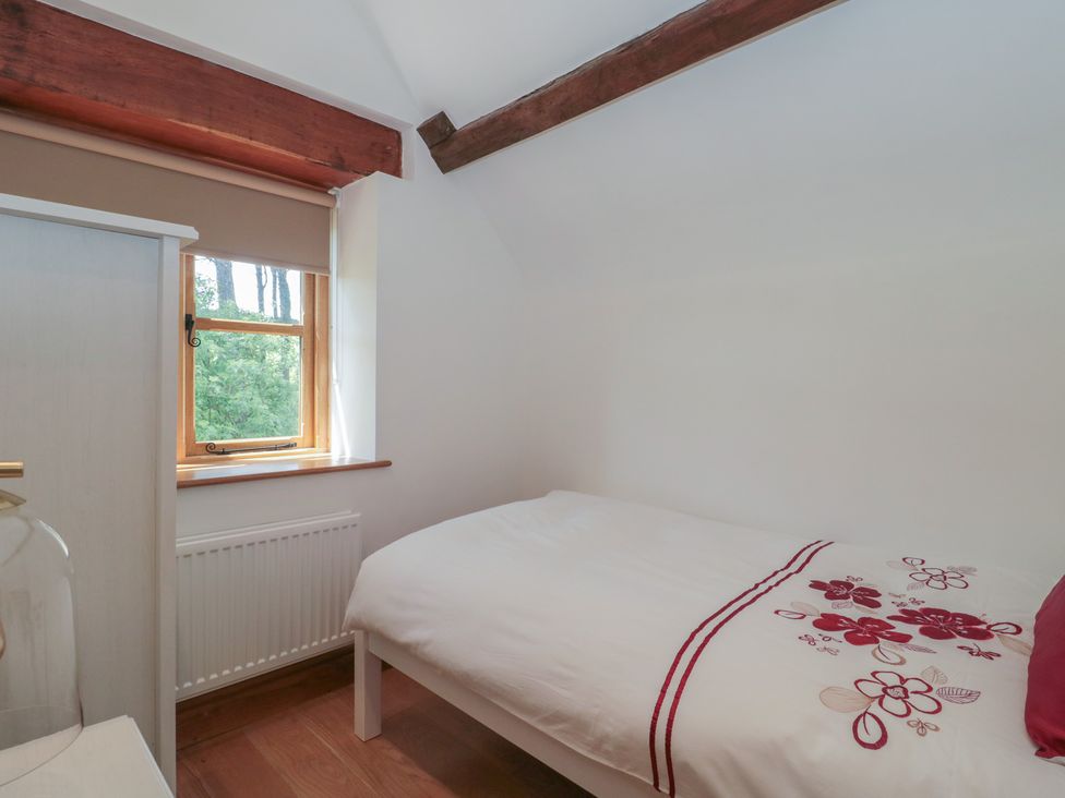 A bedroom with a bed and a window at Penrhiwarwydd Barn Pontywaun