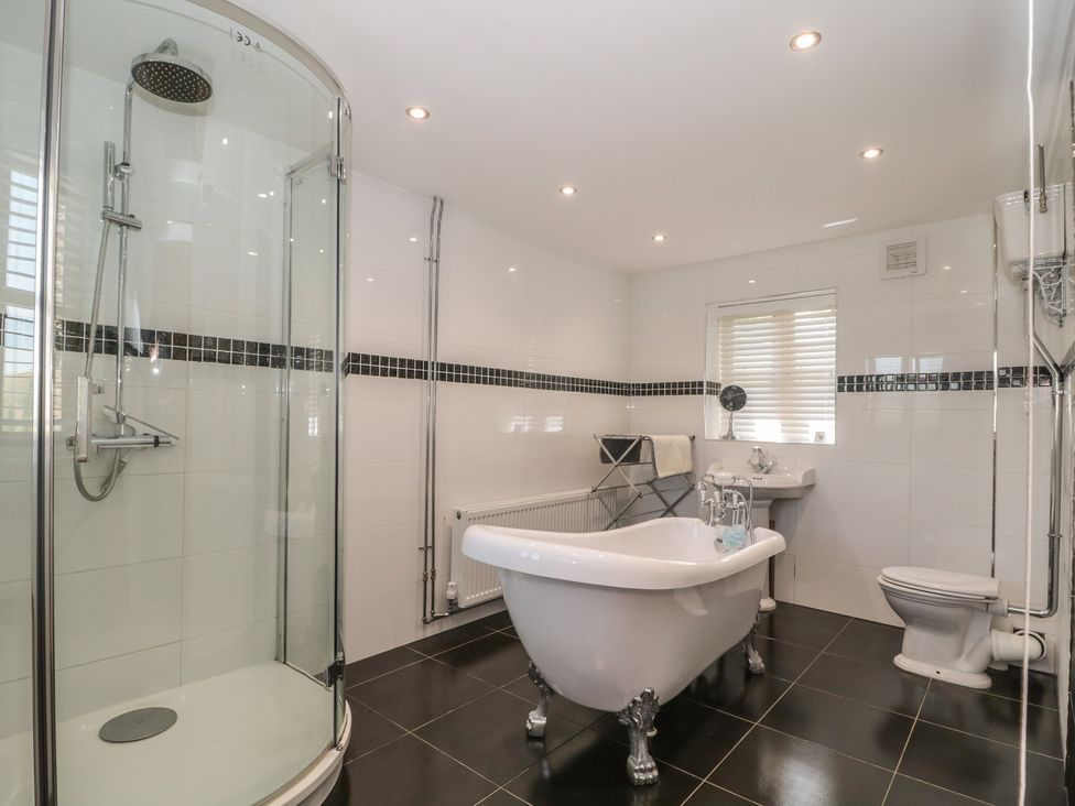 A bathroom with a shower, bathtub, sink, and toilet at Penrhiwarwydd Barn in Pontywaun