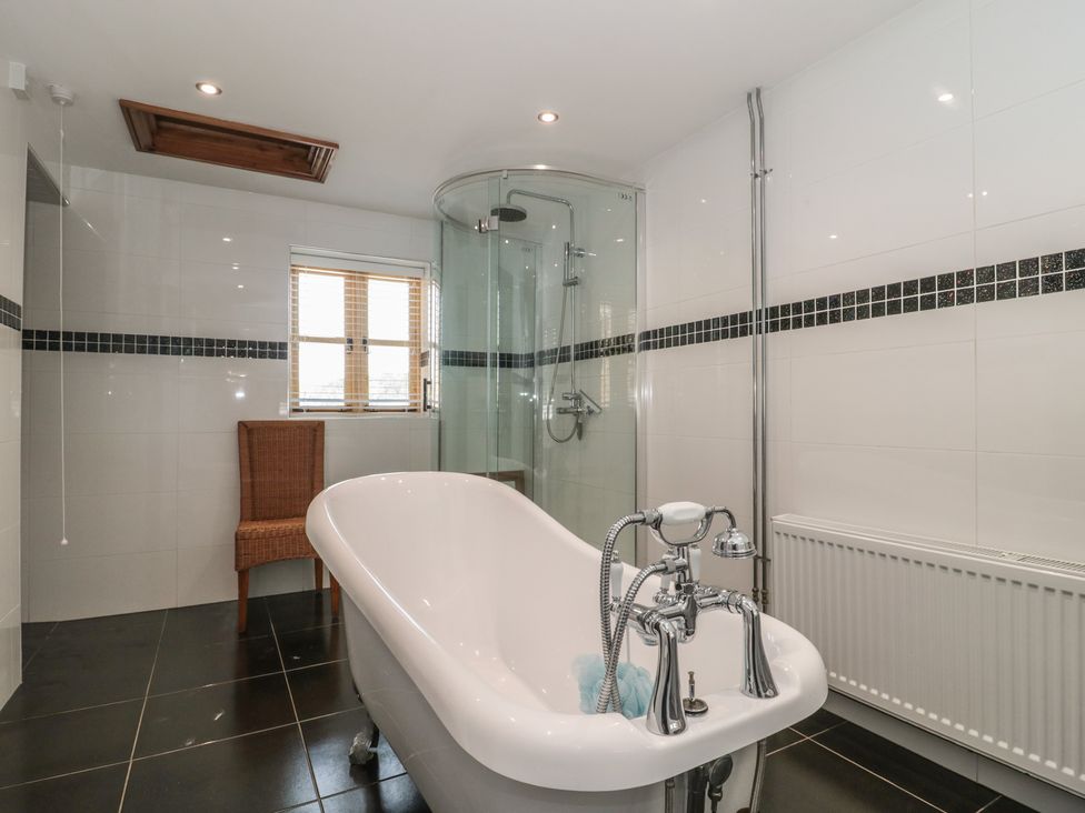A bathroom with a bath tub and shower at Penrhiwarwydd Barn in Pontywaun