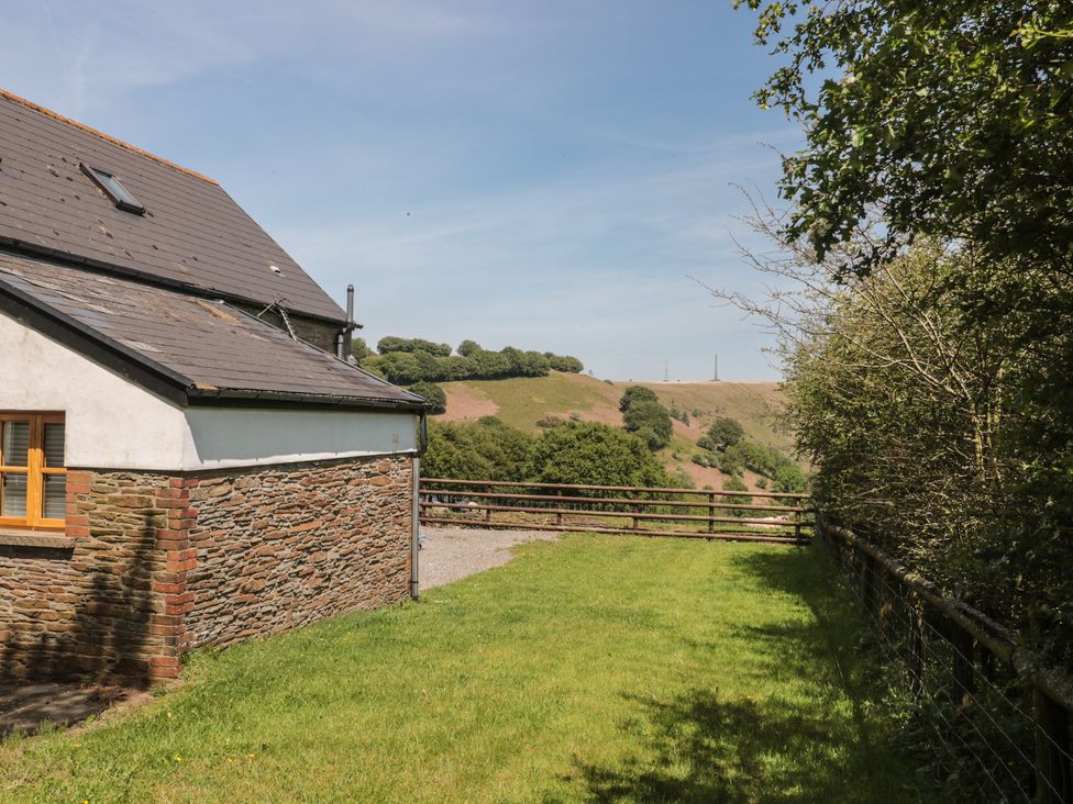 An exterior view of a property with grass and trees at Penrhiwarwydd Barn in Pontywaun