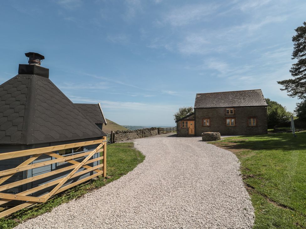 An outdoor view of a gravel pathway and a building at Penrhiwarwydd Barn in Pontywaun