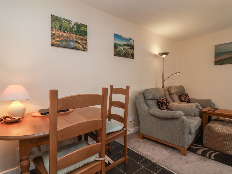 A living room with a table and chairs and a couch at Enginefield in Combe Martin