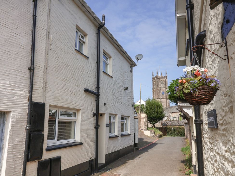 A street view with buildings and a church tower at Enginefield in Combe Martin
