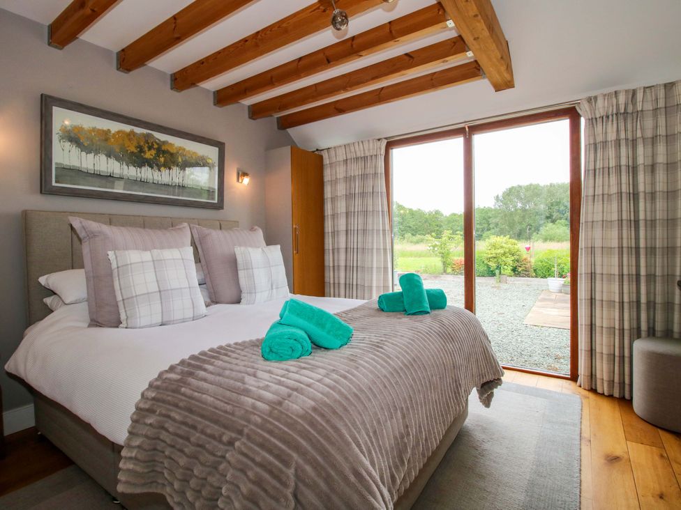 A bedroom with a bed and large window at Meeson View in Meeson near Waters Upton