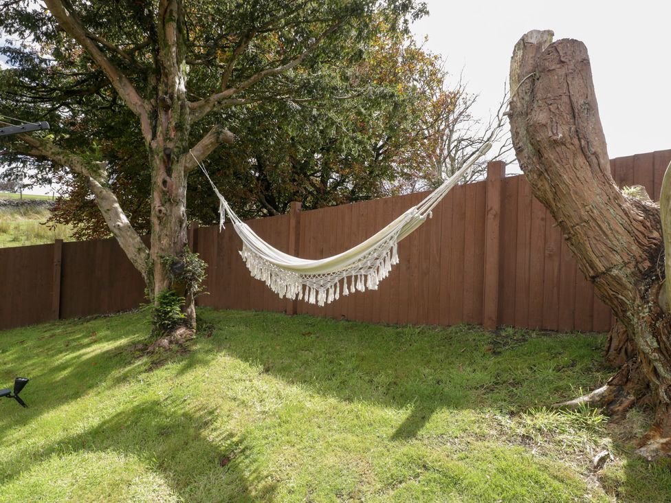 A garden with a hammock hanging between trees at Caner Bach Lodge Blackmill