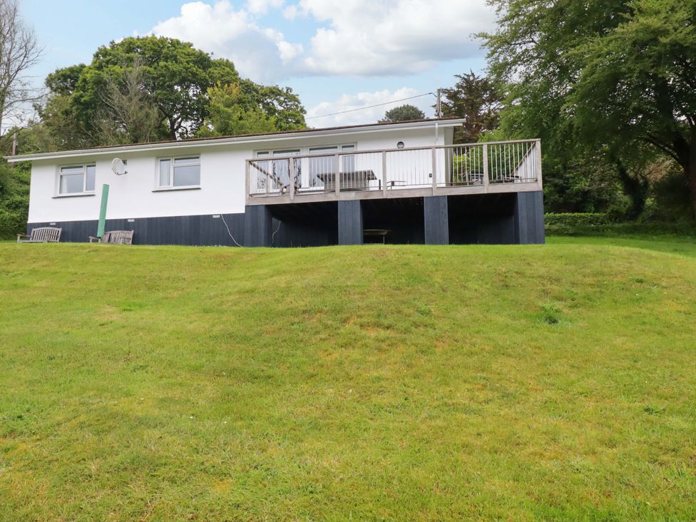 A house with a deck and benches on grass at The Meadow in Feock near Carnon Downs