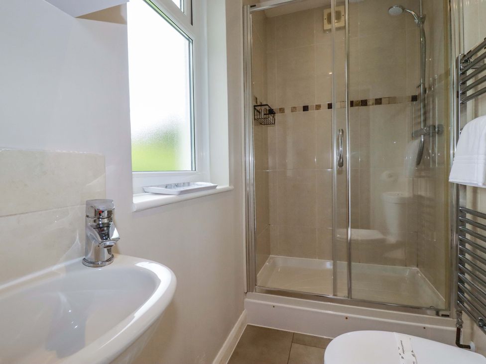 A bathroom with a shower, sink, and toilet at The Meadow in Feock near Carnon Downs