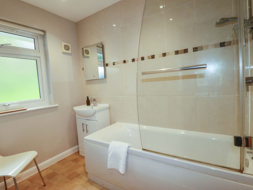 A bathroom with a bathtub and washbasin at The Meadow in Feock near Carnon Downs