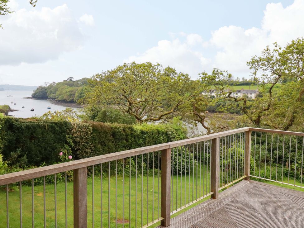 A deck overlooking water with trees and boats at The Meadow in Feock near Carnon Downs