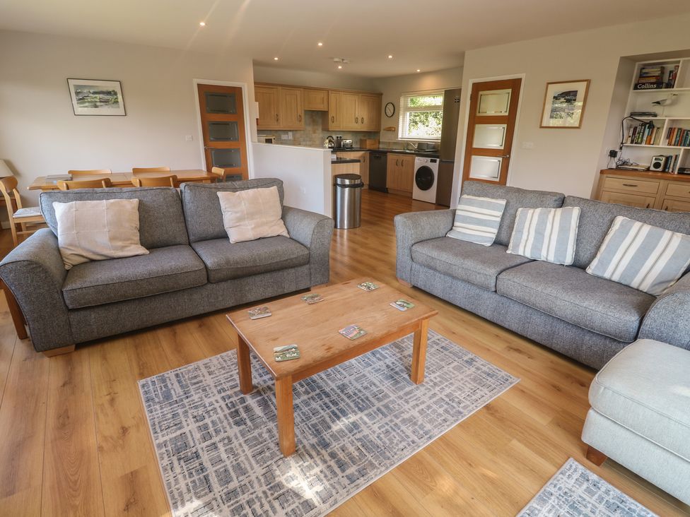 A living room with sofas and a wooden table at The Meadow in Feock near Carnon Downs