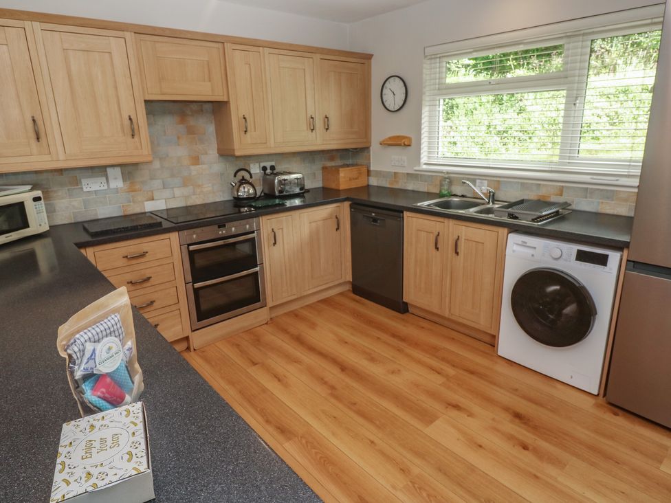 A kitchen with wooden cabinets and appliances at The Meadow in Feock near Carnon Downs