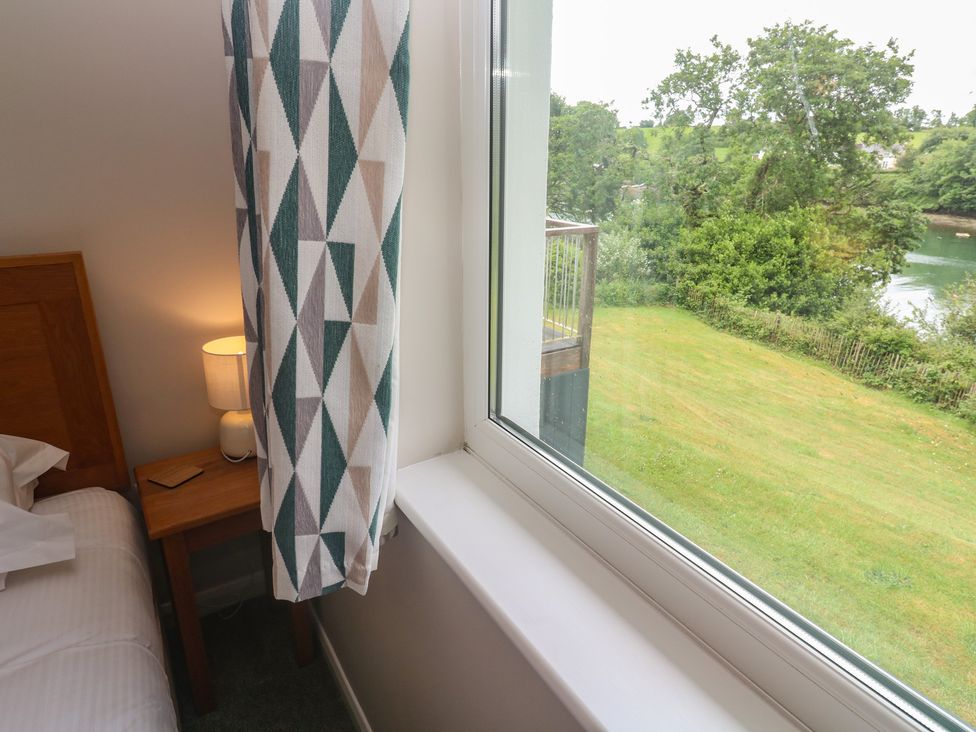 A bedroom with a bed and a window view at The Meadow in Feock near Carnon Downs
