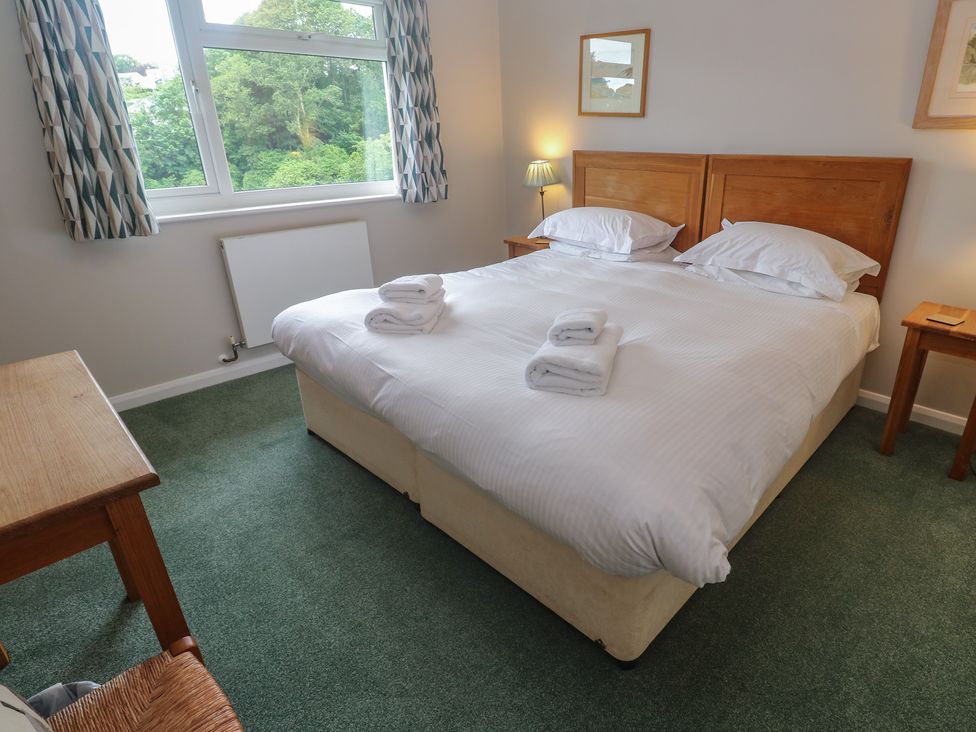 A bedroom with a bed and desk at The Meadow in Feock near Carnon Downs