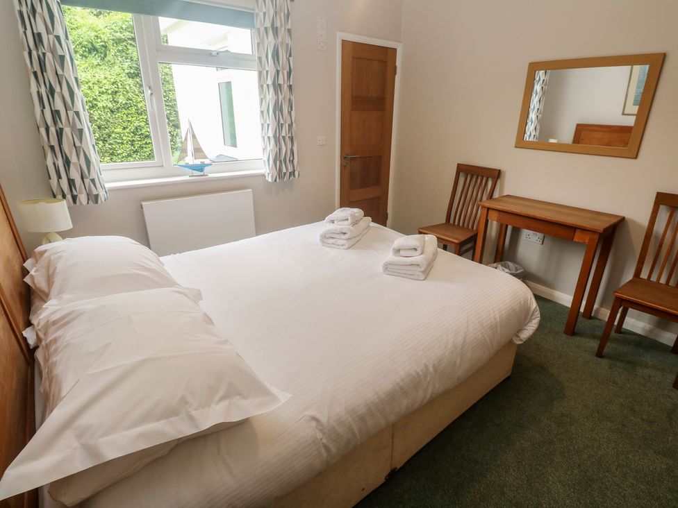 A bedroom with a bed and table at The Meadow in Feock near Carnon Downs